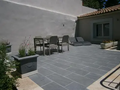a patio with chairs and a table and a building at Les Jardins de Soulane B&B - Adults only in Belcastel-et-Buc