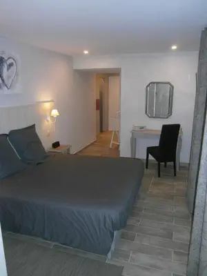 a bedroom with a bed and a desk and a chair at Les Jardins de Soulane B&B - Adults only in Belcastel-et-Buc