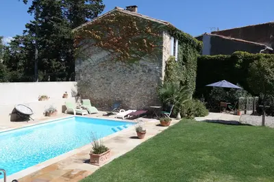 a backyard with a swimming pool and a yard with grass at The Cottage, Clos des Archers in Aigues-Vives