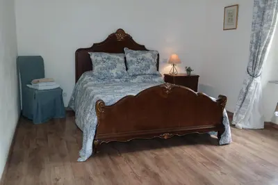 a bedroom with a large bed with blue pillows at The Cottage, Clos des Archers in Aigues-Vives