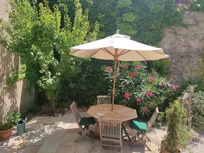 a table and chairs with an umbrella on a patio at The Cottage, Clos des Archers in Aigues-Vives