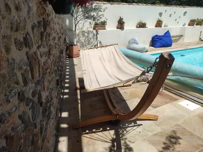 a hammock sitting next to a swimming pool at The Cottage, Clos des Archers in Aigues-Vives