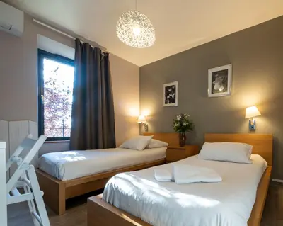 a hotel room with two beds and a window at Domaine de Garabaud in Mazères