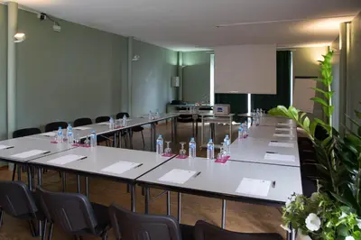 a meeting room with tables and chairs with bottles of water at Domaine de Garabaud in Mazères