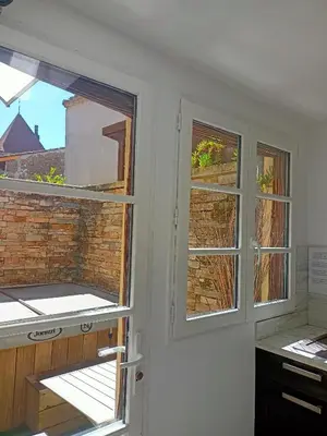 two windows in a kitchen with a brick wall at un gîte dans la cité in Carcassonne