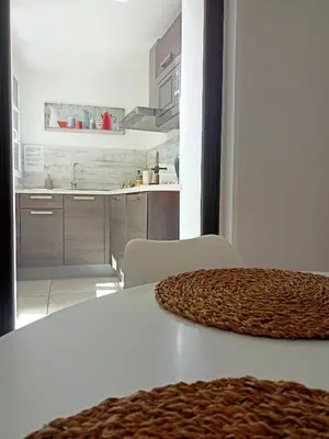 a kitchen with a white table and a white counter top at un gîte dans la cité in Carcassonne