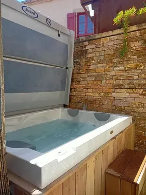 a large tub filled with water next to a brick wall at un gîte dans la cité in Carcassonne