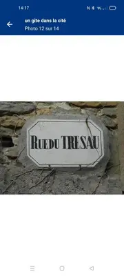 a sign sitting on the side of a building at un gîte dans la cité in Carcassonne