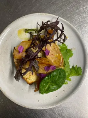 a white plate with food on a table at Mas Lluganas in Mosset