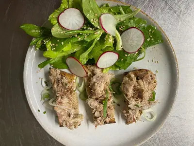 a white plate with a salad and meat and vegetables at Mas Lluganas in Mosset