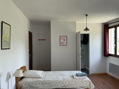 a bedroom with two beds and a bathroom at Mas Lluganas in Mosset