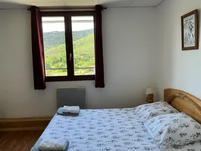 a bedroom with a bed and a window with a view at Mas Lluganas in Mosset