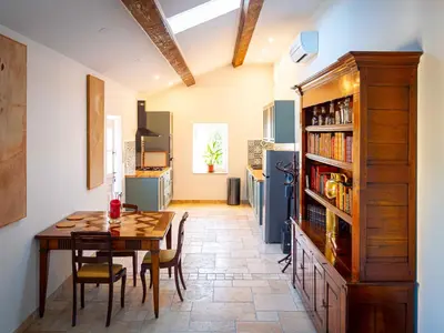 a kitchen with a table and a dining room at Gîtes la Vernède in Nissan-lez-Enserune