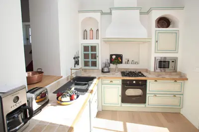 a kitchen with white cabinets and a stove top oven at Gîtes la Vernède in Nissan-lez-Enserune