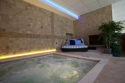 a swimming pool in a room with a couch and a chair at Gîtes la Vernède in Nissan-lez-Enserune