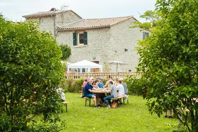a group of people sitting around a table in a yard at Domaine Calmel & Joseph in Montirat