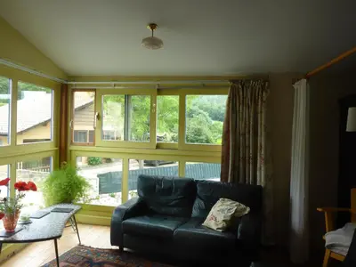 a living room with a couch and a large window at Gite Sent Martin in Roquefixade