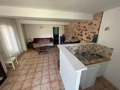 a kitchen and living room with a table and a couch at C&O Appartements in Comigne