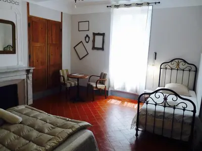 a bedroom with a bed and a table with chairs at Chez Lola-Maison d'hôtes Corbières in Durban-Corbières