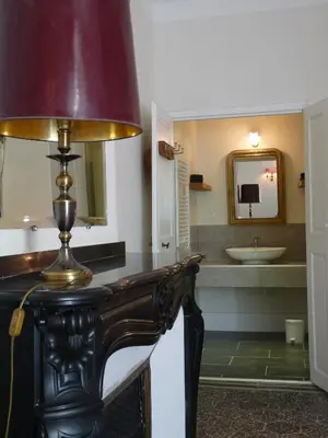a bathroom with a table with a lamp on it at Chez Lola-Maison d'hôtes Corbières in Durban-Corbières