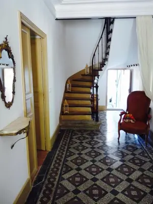 a hallway with a staircase with a chair and a rug at Chez Lola-Maison d'hôtes Corbières in Durban-Corbières