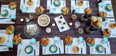 a wooden table with plates of food on it at Chez Lola-Maison d'hôtes Corbières in Durban-Corbières