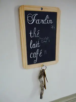 a blackboard with a pair of keys hanging on a wall at Chez Lola-Maison d'hôtes Corbières in Durban-Corbières