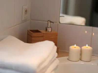 a bathroom with two candles on a sink with a mirror at Le Relais de la Maison Bacou in Carcassonne