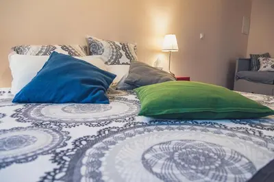 a bed with two green and blue pillows on it at H2o Chambres d'Hôtes in Peyriac-de-Mer