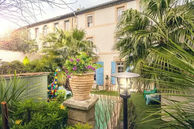 a garden with a large vase of flowers and a street light at H2o Chambres d'Hôtes in Peyriac-de-Mer