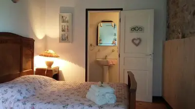 a bedroom with a bed and a mirror and a door at L'Envolée in Belvianes-et-Cavirac