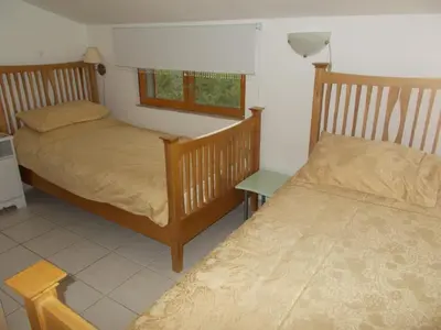 a bedroom with two beds and a table and a window at Gite Quatre Saisons 2 in Limoux