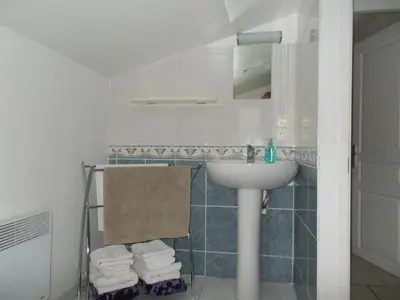 a bathroom with a sink and a mirror and towels at Gite Quatre Saisons 2 in Limoux