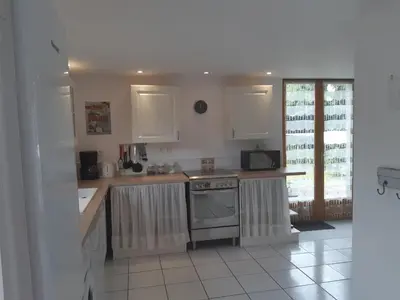 a kitchen with white cabinets and a stove top oven at Gite Quatre Saisons 2 in Limoux