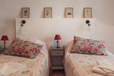 a bedroom with two beds and a night stand with lamps at Château Moussoulens in Moussoulens
