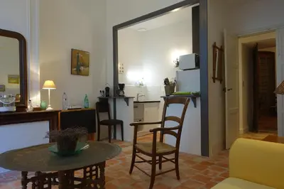 a living room with a table and a kitchen at Château Moussoulens in Moussoulens