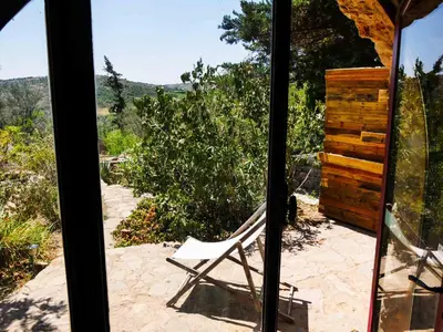 a chair sitting on a patio looking out a window at La bergerie du chateau de Fitou in Fitou