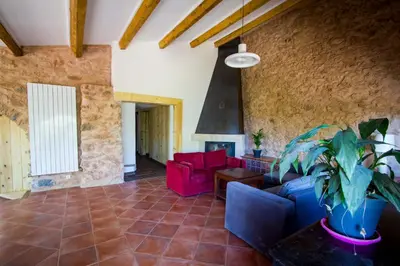 a living room with red chairs and a fireplace at La bergerie du chateau de Fitou in Fitou