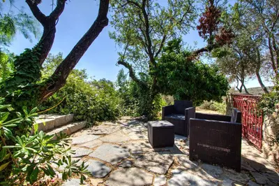a patio with a bench and a fence and trees at La bergerie du chateau de Fitou in Fitou