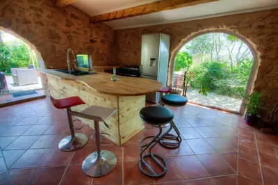 a kitchen with a counter and stools in a room at La bergerie du chateau de Fitou in Fitou