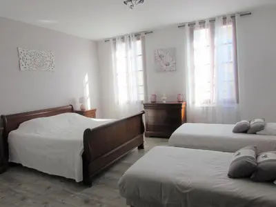 a bedroom with two beds and two windows at Les Balcons du Pastel in Puylaurens