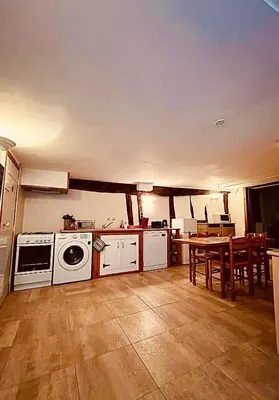 a kitchen with a table and a stove and a dishwasher at Les Balcons du Pastel in Puylaurens