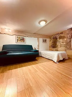 a bedroom with a couch and a bed in it at Les Balcons du Pastel in Puylaurens