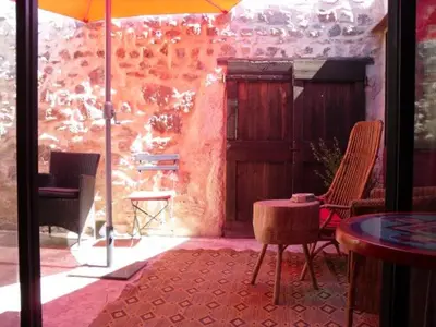 a patio with chairs and a table and an umbrella at Loft Ecologique in Villesèque-des-Corbières