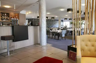 a restaurant with a dining room with tables and chairs at The Originals City, Hôtel Le Causséa, Castres in Castres