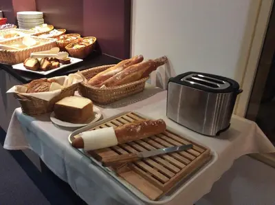 a table with bread and pastries on a table at The Originals City, Hôtel Le Causséa, Castres in Castres