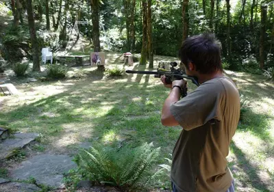 a man holding a gun in a forest at Gîte rural La Bergerie du Sant in Massaguel