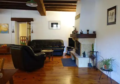 a living room with leather furniture and a fireplace at Gîte rural La Bergerie du Sant in Massaguel