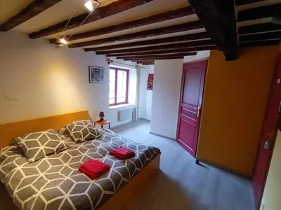 a bedroom with a bed with two red pillows on it at Terres de Barréjat in Cazals-des-Baylès
