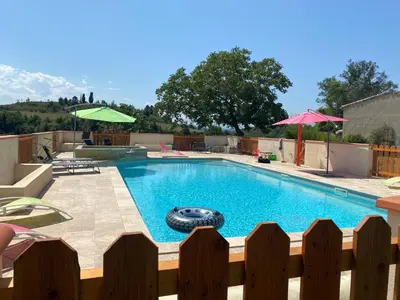 a swimming pool in a backyard with a wooden fence at Terres de Barréjat in Cazals-des-Baylès